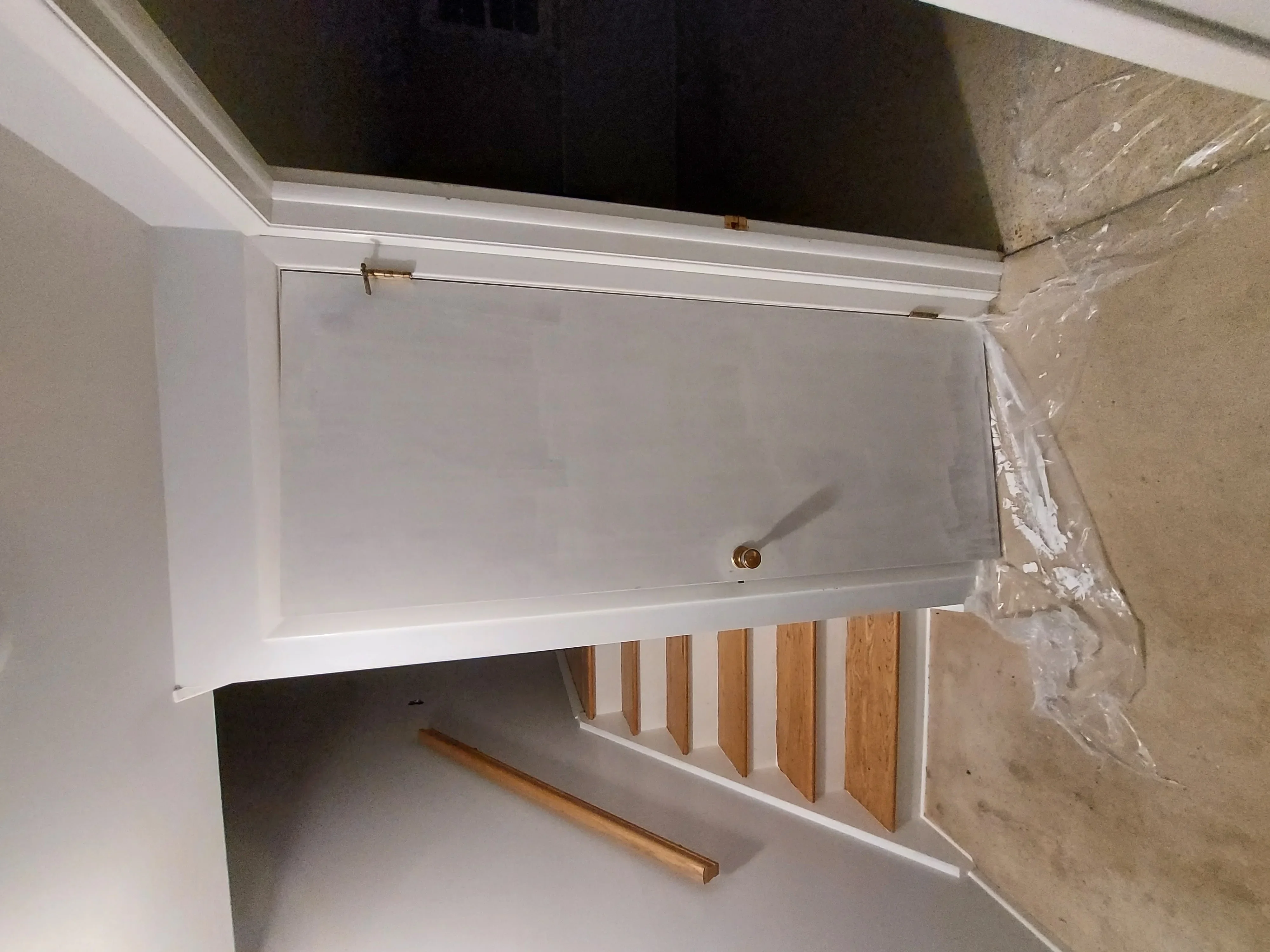 White built-in cabinet with sliding door and wooden shelf dividers installed in wall opening