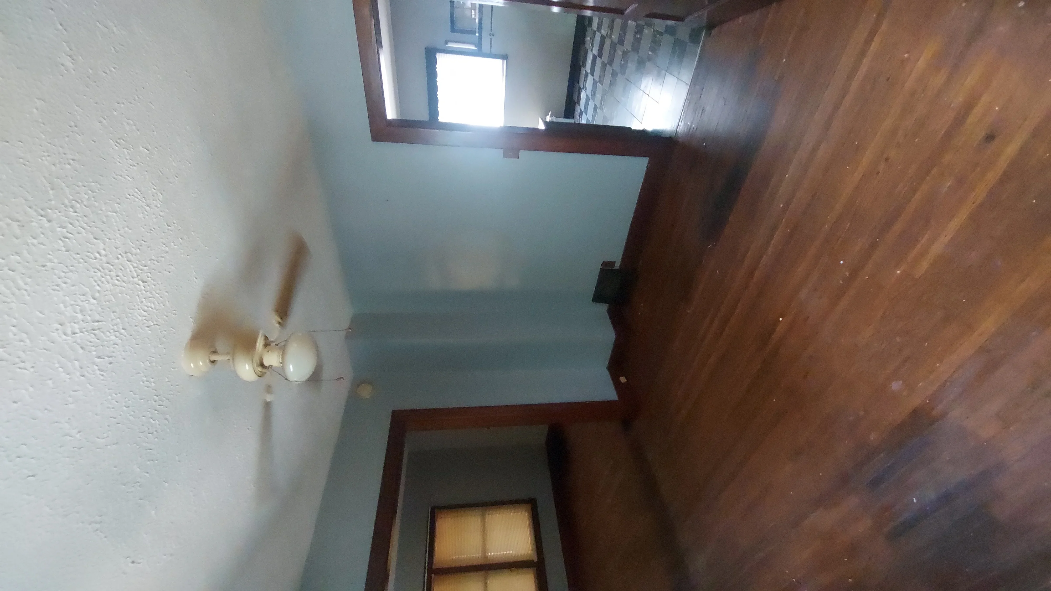 Drywall walls with textured finish, wood trim framing, and electrical outlet installation in renovated interior space