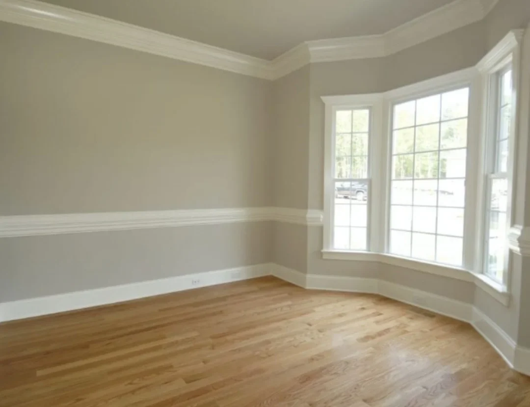 Renovated room with hardwood floors, two-tone painted walls, white trim, and bay window with grid panes